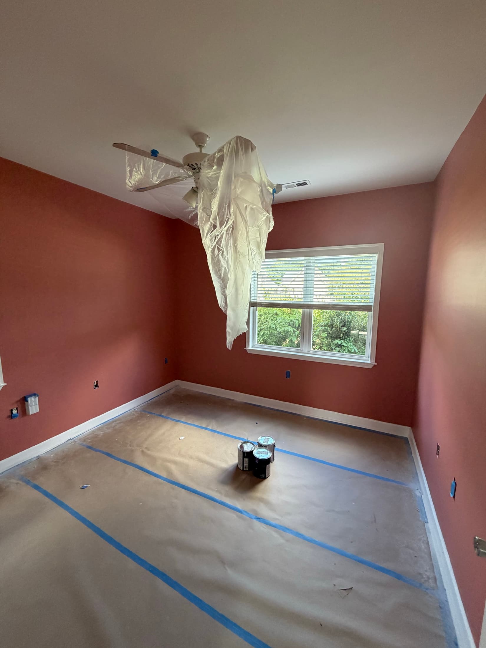Terracotta bedroom with floor fully papered and the fan bagged